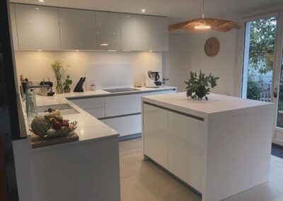 Cuisine moderne entièrement blanche avec armoires élégantes et plan de travail lumineux à Tarbes